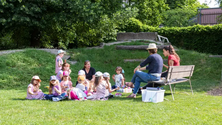 Kinder und pädagogische Fachkräfte bei einer gemeinsamen Aktivität im Freien